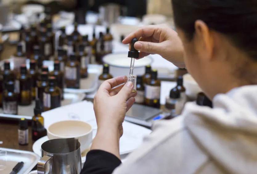 Master perfumer carefully measuring precious oils in our laboratory